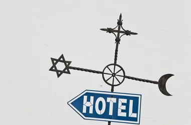 Straßenschild mit jüdischen, christlichen und islamischen Symbolen